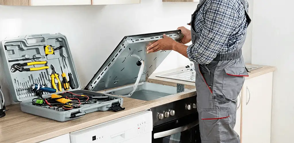 Handyman repairing a cooktop and checking wiring connections in San Francisco, CA