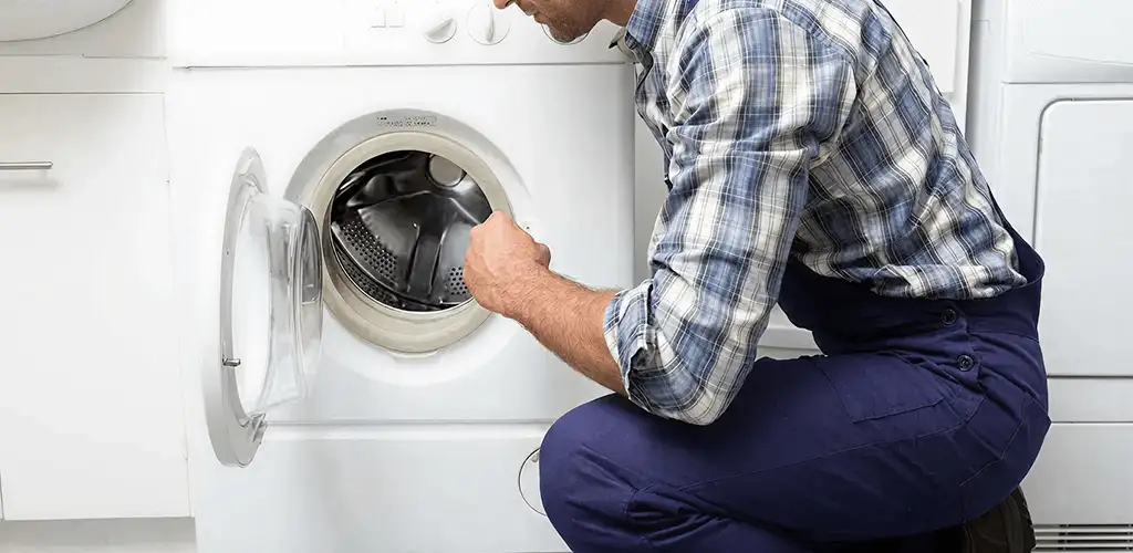 Handyman inspecting a dryer drum and internal parts for repair in San Francisco, CA