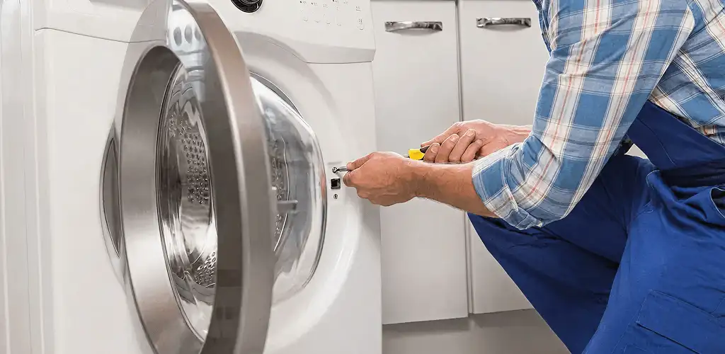 Handyman repairing a clothes dryer and checking electrical connections in San Francisco, CA