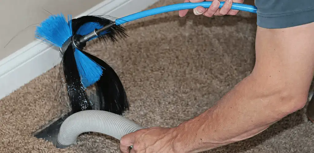 Dryer vent cleaning technician brushing lint from a vent line in San Francisco, CA
