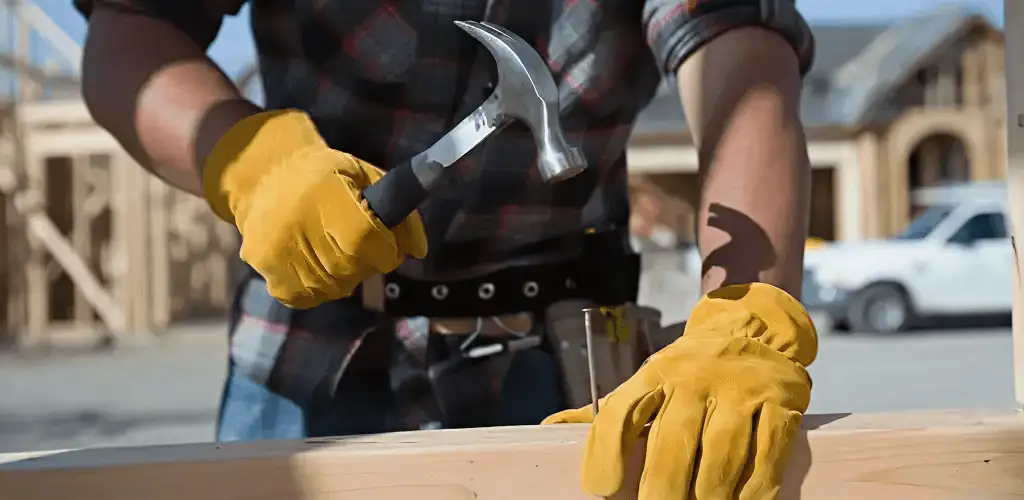 Handyman fixing wood trim with a hammer for home repairs in San Francisco, CA