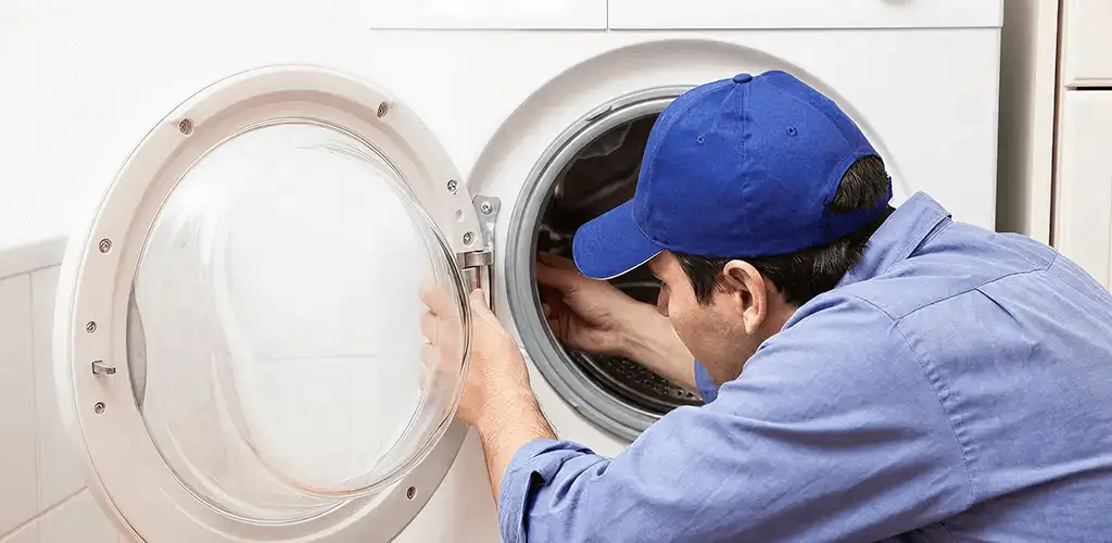 Washing machine repair handyman inspecting a front-load washer drum in San Francisco, CA