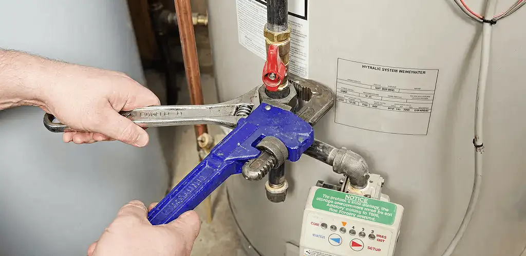 Water heater repair technician tightening the shutoff valve and supply line in San Francisco, CA